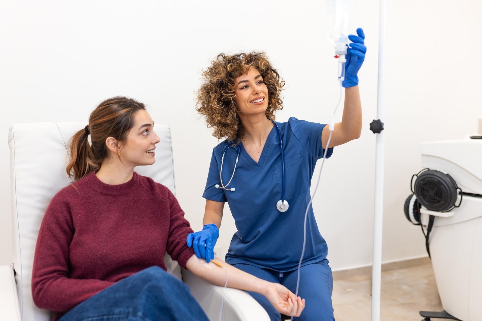 Profesional de salud atendiendo a una paciente durante terapia intravenosa